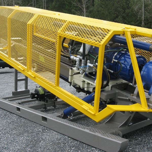 Yellow expanded metal machine guards are installed on the drilling equipment.