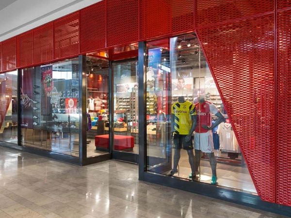 Red expanded metal decorative walls are installed outside the cloth shop.