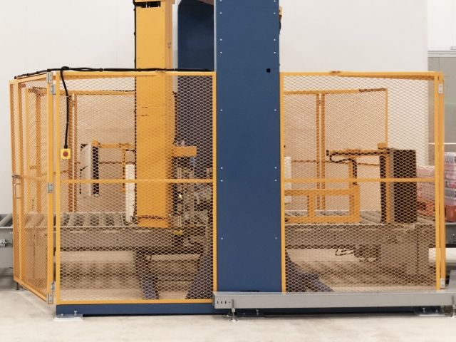 Expanded metal machine perimeter guards are installed around the production equipment.