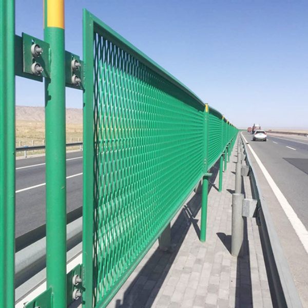 Green anti-glare expanded metal fence is installed along the highway isolation strip.