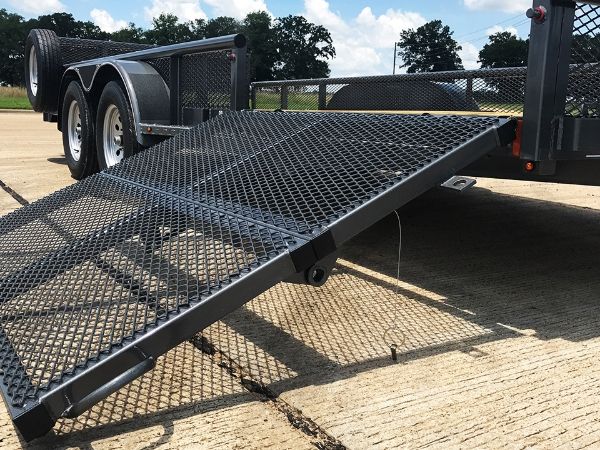 Black expanded metal trailer ramps are installed on the trailer.