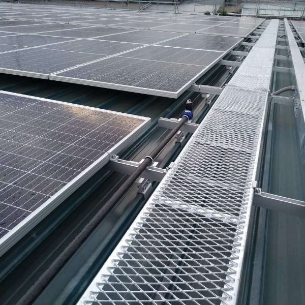Expanded metal walkway is laid between solar panels.