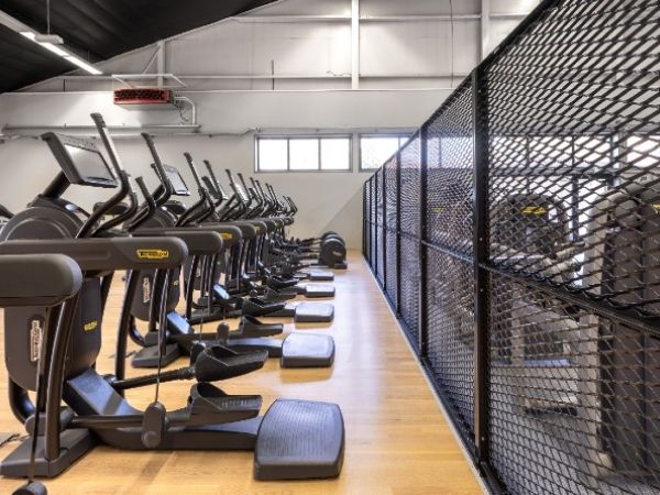 Black expanded metal partition is installed in the fitness room.