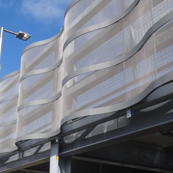 Wave-shaped expanded metal facade is installed on the parking lot.